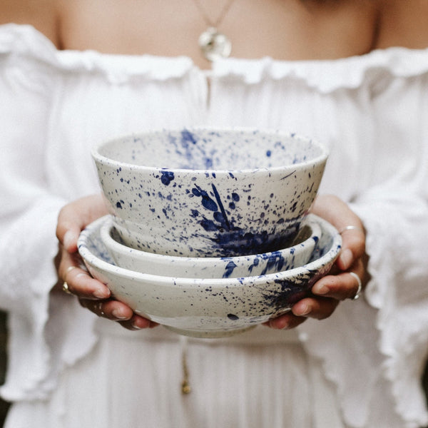 Woman holding hand-painted white and blue bowls