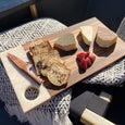 Cheese plate on a wooden serving board with a wooden knife