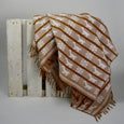 Handwoven patterned throw on a wooden skid