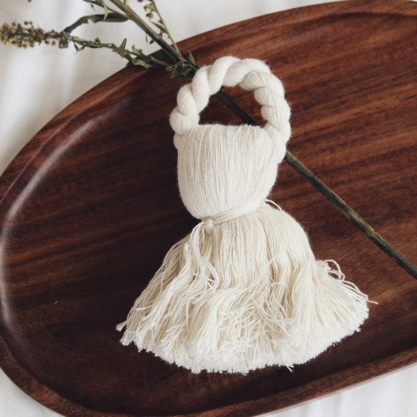 Close up of white tassel napkin ring on a wooden board