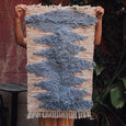 Person hanging a cotton woven rug