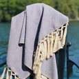Blue textured blanket on a chair near a lake