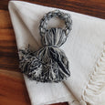 Black and white tassel napkin ring on white fabric and wooden background