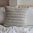 Textured cotton accent pillow on a bed