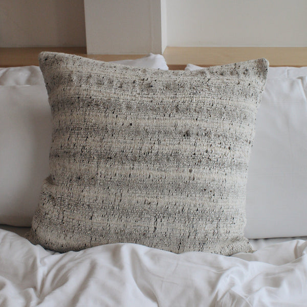 Textured cotton accent pillow on a bed