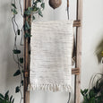 Textured black and white rug hanging on a wooden ladder 