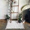Wooden ladder with a textured rug and plants