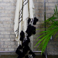 Black and white textured blanket hanging on a clothing rack